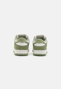 Nike Dunk sportcipő világoszöld színben, texturált zöld állatmintával. A dizájn fehér részletekkel és párnázott nyelvvel rendelkezik a kényelem érdekében.
