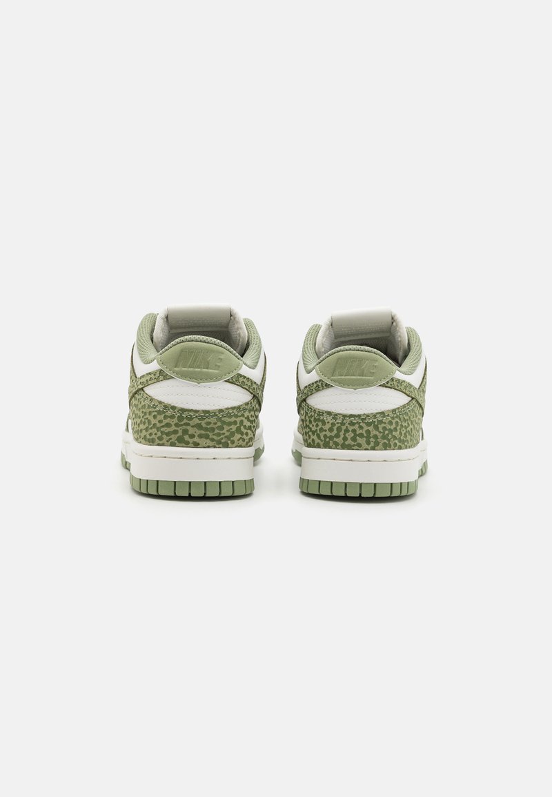 Baskets Nike Dunk en vert clair avec un imprimé animal texturé en vert. Le design comprend des accents blancs et une languette rembourrée pour le confort.