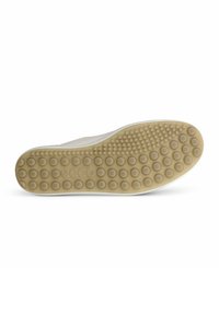 Semelle de chaussure en beige clair avec des motifs de grip circulaires et de petites bosses. Design plat, fabriqué en caoutchouc, offrant traction et soutien.