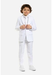 Abito bianco con giacca monopetto e pantaloni coordinati, abbinati a una camicia e cravatta bianche. Tessuto liscio, linee pulite, bottoni minimi.