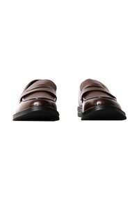 Paire de mocassins en cuir marron foncé avec semelles noires, vus de face sur fond blanc.