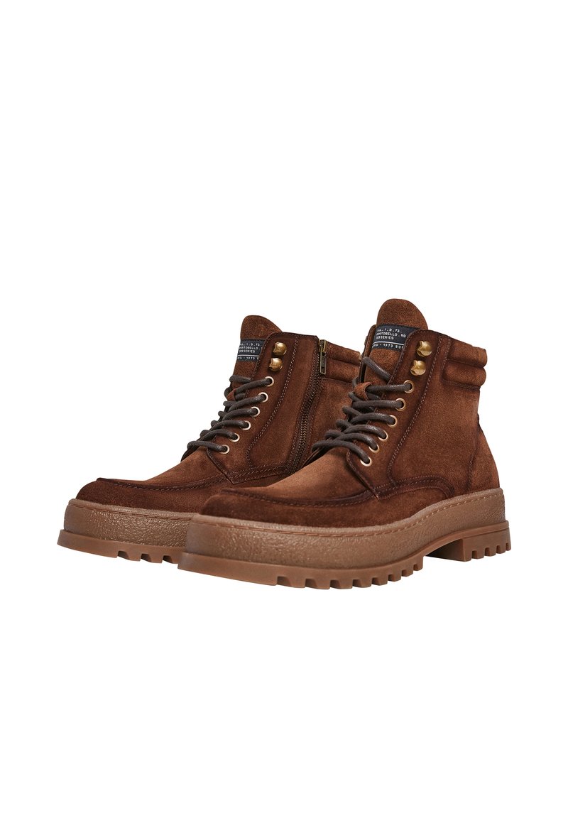 Botas de senderismo de ante marrón con punta redonda, cuello acolchado, cierre de cordones y cremallera, suela de goma texturizada y ojales en tono dorado.