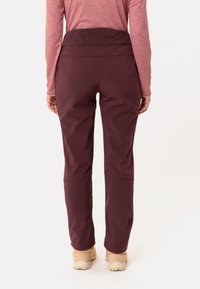 Bordeaux buitenbroek van glad, rekbaar materiaal met een hoge taille. Kenmerken zijn een platte tailleband en taps toelopende pijpen.