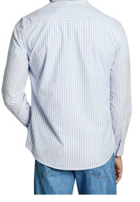 Camicia a maniche lunghe a strisce blu chiaro e bianche, in misto cotone, con polsini abbottonati, design con yoke posteriore, orlo curvo, vestibilità rilassata.