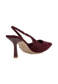 Zapato de tacón alto de ante burdeos, con diseño de slingback, punta afilada y tacón de aguja delgada, mostrado de lado sobre fondo blanco.