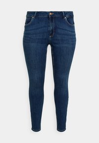 Dark blue denim skinny jeans with a mid-rise waist, featuring five pockets and copper hardware detailing. Smooth texture and fitted shape.