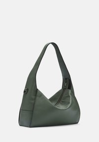 Zielona skórzana torba na ramię o miękkiej, teksturowanej powierzchni, wyposażona w unikalny kształt kątowy i zamek błyskawiczny po jednej stronie.