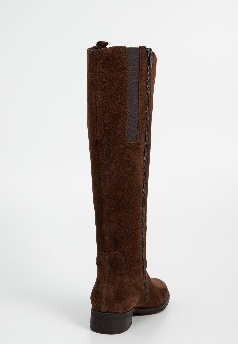Brązowe zamszowe kozaki do kolan z bocznym zamkiem błyskawicznym i elastycznym panelem dla lepszego dopasowania. Solidny brązowy obcas i gładka faktura.