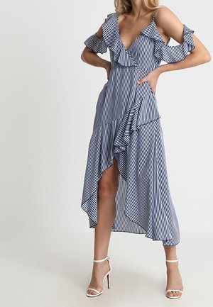 Gestreepte jurk met ruches, diepe V-hals en cold shoulder ontwerp. Voorzien van een vloeiende asymmetrische zoom in marineblauw en wit.