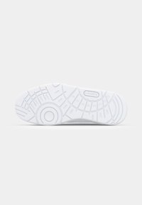 Biała podeszwa trampka z teksturowanymi wzorami, okrągłymi i liniowymi motywami, z logo Lacoste na podniesionej sekcji.