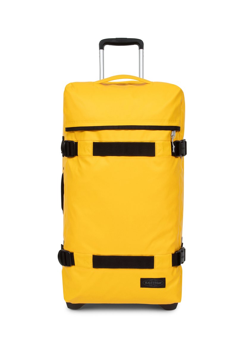Valigia gialla con ruote, manico estraibile, dettagli neri, chiusura con zip e cinghie di compressione. Realizzata in tessuto resistente.