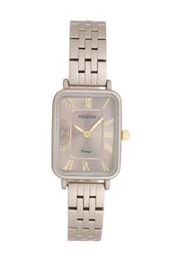 Montre vintage rectangulaire avec un bracelet en métal bronze, un cadran gris, des chiffres romains dorés et une petite couronne dorée sur le côté.