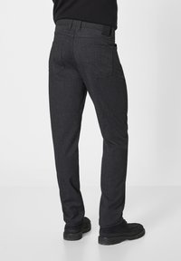 Dark gray trousers made from a textured material, featuring a straight fit, back pockets, and stitched detailing. Accented with a black waistband.