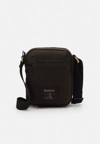 Dark green crossbody bag made of durable fabric, featuring a front pocket, adjustable strap, and a label with logo and design detail.