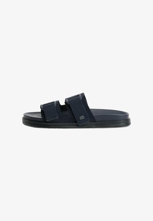 Schwarze Slides-Sandale mit zwei verstellbaren breiten Riemen und flacher Sohle, seitlich vor weißem Hintergrund dargestellt.