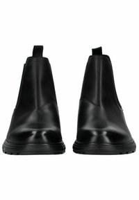 Botas de tobillo negras de cuero con textura suave, paneles laterales elásticos y una suela de goma gruesa. Sin herrajes ni patrones visibles.