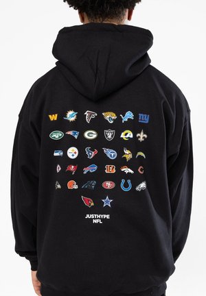 Sudadera negra con capucha que presenta los logotipos de equipos de la NFL impresos en la parte trasera en varios colores, con el texto "JUSTHYPE NFL" en la parte inferior. Material de algodón, ajuste casual.