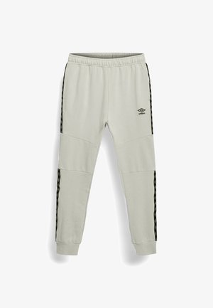 Joggers atletici grigio chiaro con girovita elastico, caviglie risvoltate, strisce laterali nere con motivo e logo Umbro sulla coscia destra.