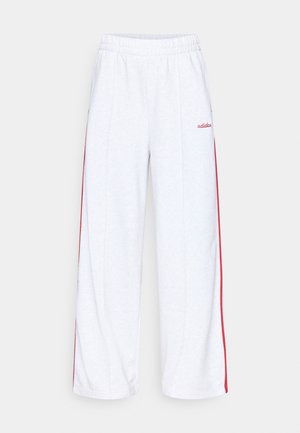 Pantaloni de trening albi cu talie elastică, cu dungi laterale roșii și logo brodat pe șoldul stâng. Material moale și ușor.