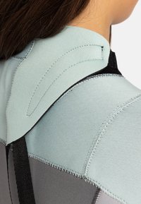 Neoprenanzug im Schulterbereich mit einem hellblauen oberen Abschnitt und einem grauen unteren Abschnitt. Strukturmaterial mit genähten Nähten und schwarzen Akzenten.