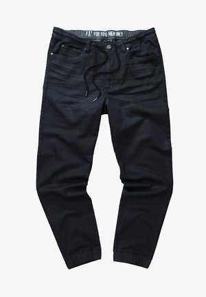 Schwarze Jogginghosen mit elastischem Bund, Kordelzug und Bündchen an den Knöcheln. Glatte Textur mit subtilen diagonalen Linien über den Stoff.