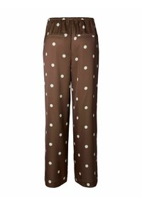 Brune bukser med prikkemønster, elastisk midje og to baklommer. Laget av et glatt stoff med store, kremfargede prikker.