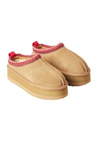 Scarpe slip-on in camoscio beige con un bordo intrecciato rosso e un anello sul retro. Suola in gomma spessa con superficie texturizzata per una migliore aderenza.