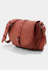 Červená kožená crossbody taška s texturovaným povrchem, zakřiveným klopou a nastavitelným popruhem. Obsahuje stříbrné kovové detaily a dekorativní uzlové akcenty.