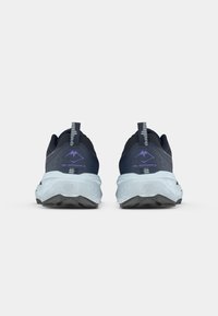 Blå og svarte joggesko med en teksturert overdel, synlig merkevare, og en tykk lyseblå mellomsåle. Mønsteret på sålen er tydelig.