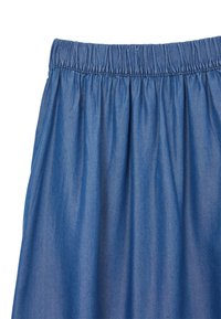 Jupe en denim avec une taille élastique, présentant un design plissé. Le tissu est lisse, d'une couleur bleu moyen et possède une texture légère.