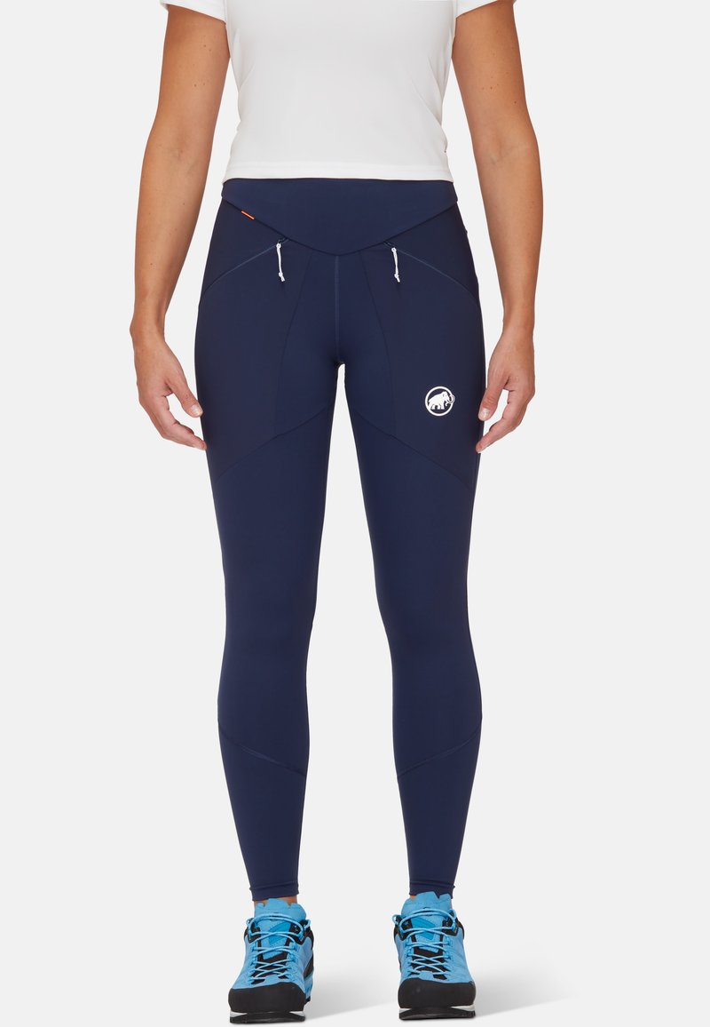Legging bleu marine avec une taille haute, comprenant deux poches avant avec fermetures éclair et un logo sur la cuisse gauche. Fabriqué en matériau extensible.