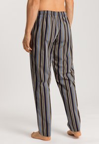 Gestreepte pyjamabroek in blauw, marineblauw en geel. Gemaakt van zachte stof, met een elastische tailleband en een rechte pijpdesign.