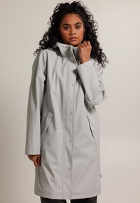 Light gray waterproof raincoat, snap buttons, high collar, two side pockets, smooth texture, knee-length design.