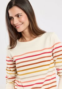 Langærmet cremet sweater med horisontale striber i nuancer af pink, rød, orange og brun. Har en rund halsudskæring og blød tekstur.