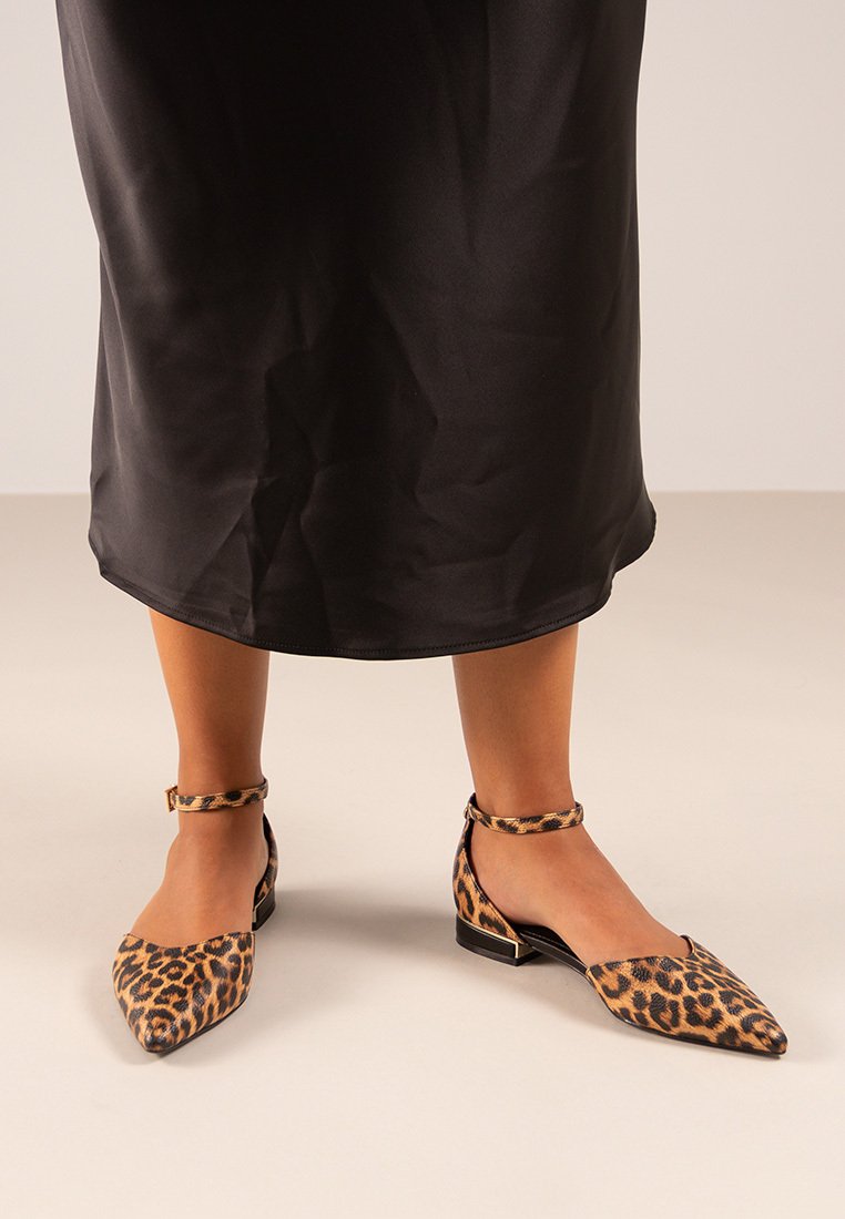 Bailarinas de print de leopardo con punta afilada, tiras para el tobillo y tela texturizada. Diseño clásico en una combinación de colores marrón y negro.