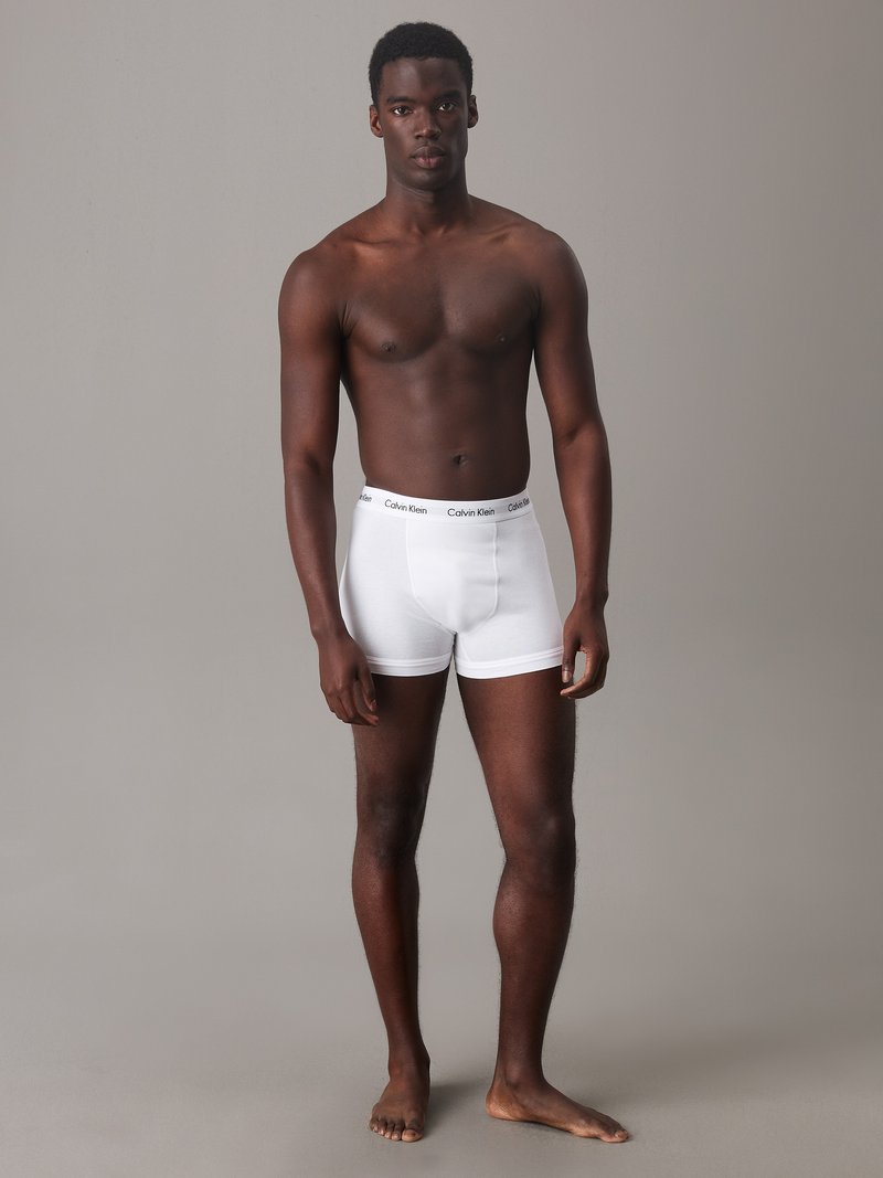 White cotton boxer shorts with elastic waistband featuring the Calvin Klein logo, fitted design, no patterns, and a smooth texture.