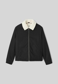 Veste noire avec col en fausse fourrure crème, fermeture éclair à l'avant et deux poches sur les côtés. Présente une texture lisse et une coupe standard.