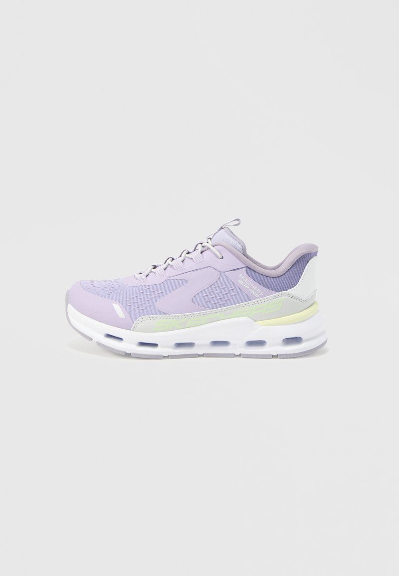 Ανοιχτό μωβ αθλητικό παπούτσι Skechers με λευκή και ανοιχτό κίτρινη σόλα, επάνω μέρος από δίχτυ και δέσιμο με κορδόνια, εμφανίζεται από την εξωτερική πλευρά.
