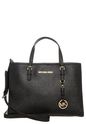 Sac à main en cuir noir Michael Kors avec deux poignées, une bandoulière amovible et un charm logo doré suspendu sur le devant.