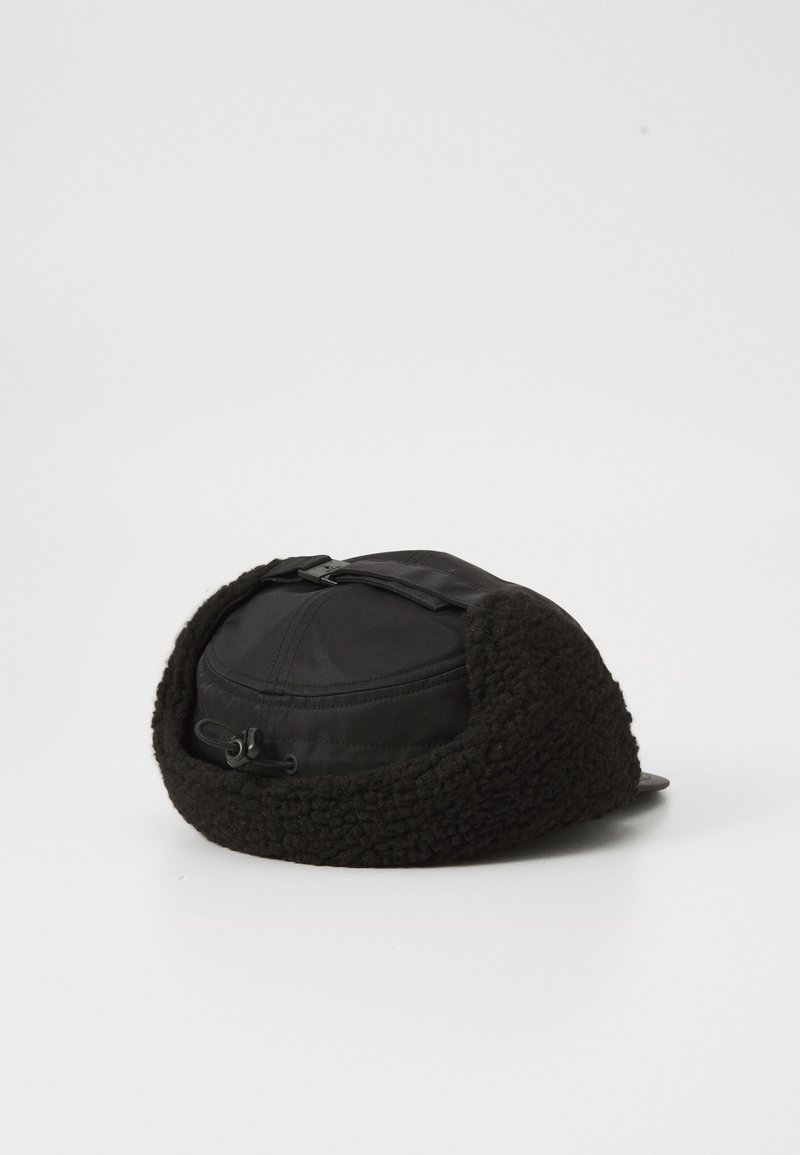 Zwarte hoed met een zachte fleece buitenkant en een gladde stoffen bovenkant. Centrale verstelband, licht gebogen rand en ronde vorm.