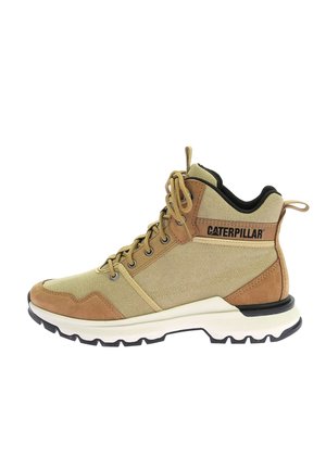 Tannfarbene und beige Wanderschuhe mit einem Obermaterial aus Stoff und Wildleder, runder Zehenform und schwarzer Gummisohle. Sie verfügen über eine Schnürung und ein Markenlogo an der Seite.