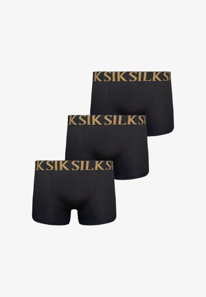 Trzy czarne męskie bokserki z złotymi elastycznymi pasami z powtarzającą się nazwą marki dużymi wielkimi literami.