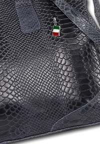 Dark navy handbag with a textured, snake-skin pattern. Features a silver charm with an Italian flag. Smooth leather accents.