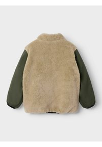 Beež sherpa-fliisist keha oliivsest rohelisest pikkade varrukatega, püstkraega ja elastsete varrukaotstega tavalise hele tausta ees.