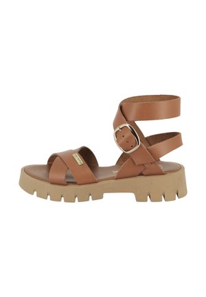 Sandal in pelle marrone con punta aperta, cinturini incrociati e una larga cinghia per la caviglia fissata da una fibbia argentata. Suola testurizzata con scanalature.