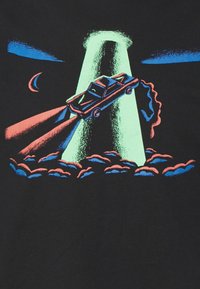 Svart t-shirt med en grafik av en bil som blir bortförd av ett UFO, med ljusa blå och rosa accenter mot en mörk bakgrund.