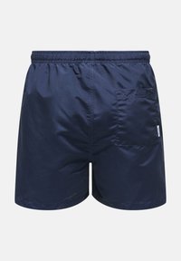 Bañador azul marino hecho de tejido ligero. Cuenta con una cintura elástica y un único bolsillo trasero con solapa. Textura lisa y mate.