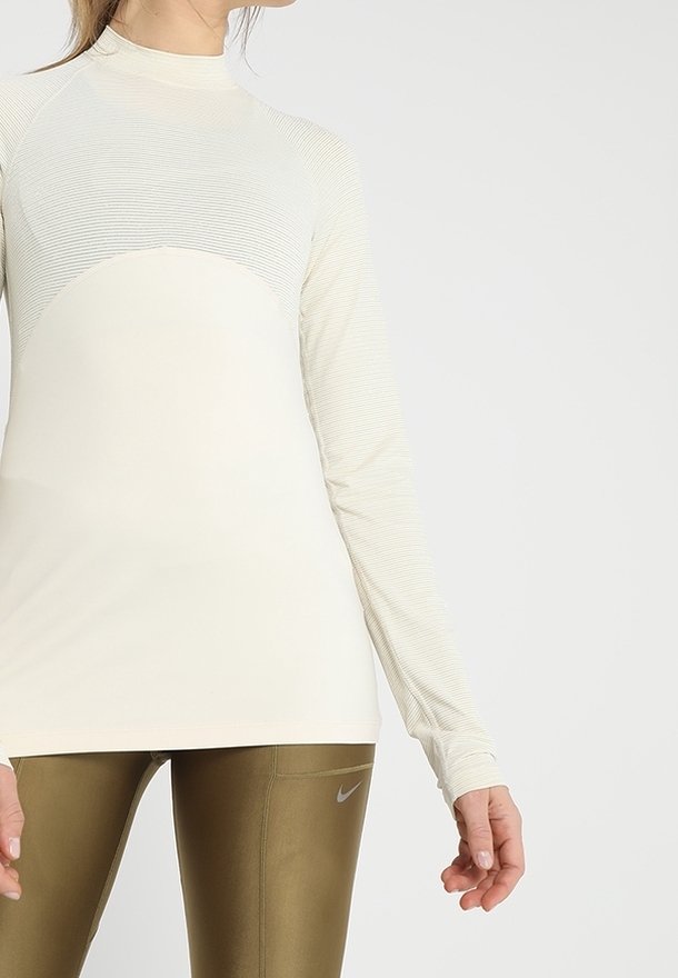 Długi rękaw sportowy top w kolorze off-white z teksturowanym paskowanym wzorem, z wysokim kołnierzem i dopasowanym krojem.