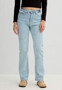 Vaqueros de pierna recta azul claro en denim con cintura alta, que cuentan con un diseño clásico de cinco bolsillos y detalles de costura.