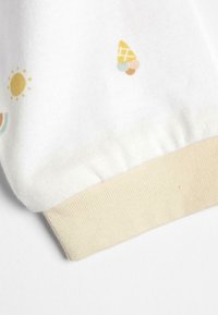 White fabric sleeve featuring colorful ice cream, sun, and abstract designs. Ribbed beige cuff at the end, soft texture.